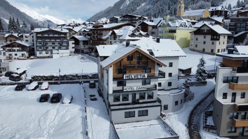 a town in the snow with buildings at Hotel Garni Helvetia in Ischgl