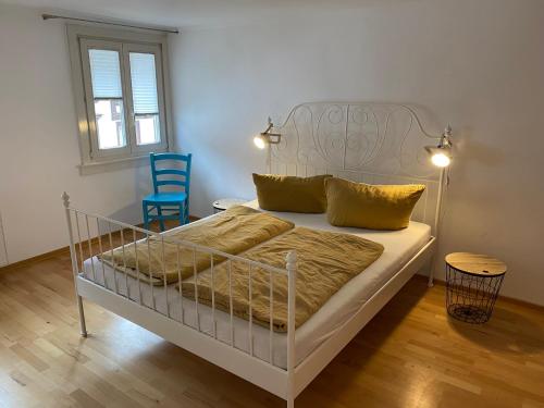 een slaapkamer met een wit bed en een blauwe stoel bij Self-check-in zentrale Fewos in Triberg - Nah am Wasserfall - in Triberg