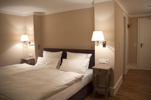 エルトフィレ・アム・ラインにあるWeinhotel Eltvinumのベッドルーム1室(白いシーツとランプ2つ付)