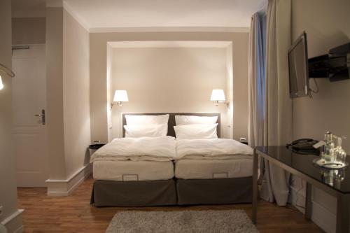 エルトフィレ・アム・ラインにあるWeinhotel Eltvinumのベッドルーム1室(白いシーツと枕のベッド1台付)