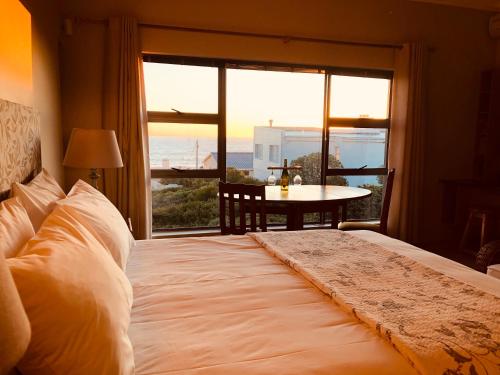 een slaapkamer met een bed en een groot raam bij Marine 5 Boutique Hotel in Gansbaai