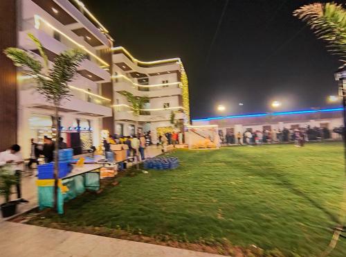 a group of people standing outside of a building at night at AKS INTERNATIONAL HOTEL AND RESORT in Sasarām