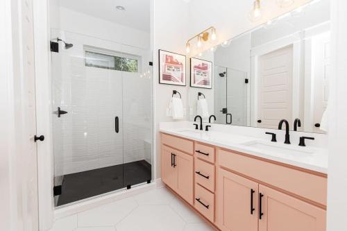 La salle de bains est pourvue de 2 lavabos et d'une douche en verre. dans l'établissement Designer Single Family House-Rooftop- Hot Tub, à Nashville