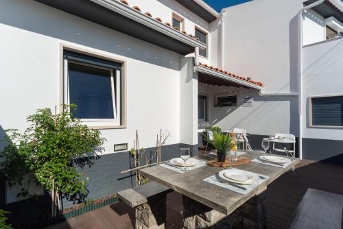 a wooden table on the patio of a house at Fika Guest House in Nazaré