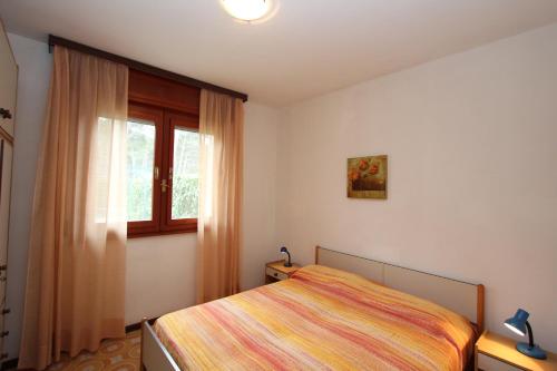 a bedroom with a bed and a window at Mughetto in Bibione