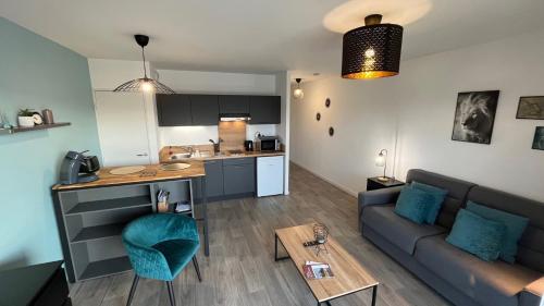 un salon et une cuisine avec un canapé et une table dans l'établissement La Bri'Z de Dinard, à Dinard