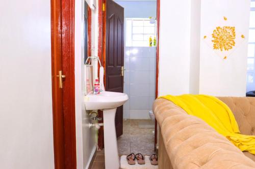 a bathroom with a sink and a couch in a room at Kay homes in Nairobi