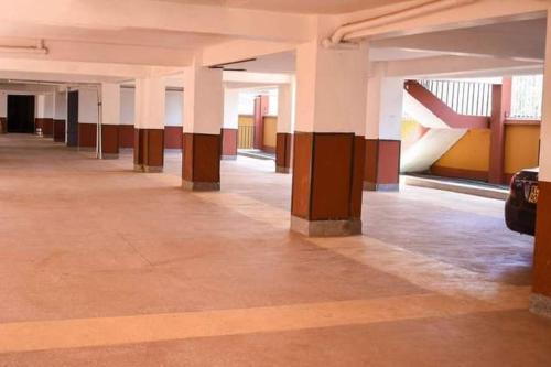 un pasillo vacío de un edificio con columnas y mesas en Kay homes en Nairobi