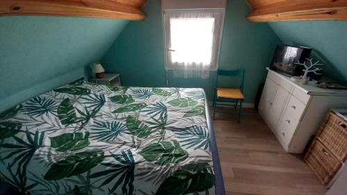 サント・メール・エグリーズにあるMaison de plage avec accès direct à la plageのベッドルーム1室(緑と白の掛け布団付きのベッド1台付)