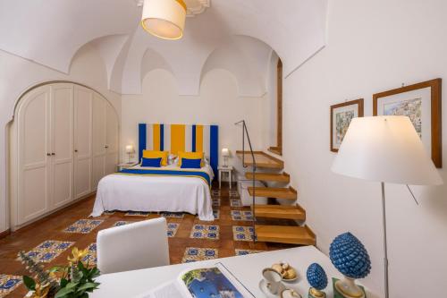 una camera da letto con letto con accenti blu e gialli di Casa Mercè Positano a Positano