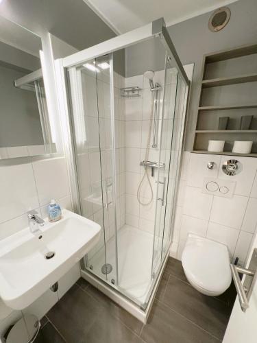 a bathroom with a shower and a sink and a toilet at Ferienwohnung Westerland strandnah Balkon Strandläufer 1 & 2 in Westerland