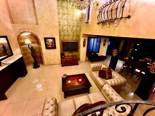 uma grande sala de estar com um sofá e uma televisão em Queens Suite Hotel em Beirute