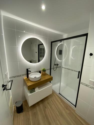 een badkamer met een wastafel en een douche met een spiegel bij LAR DE SEFA in Redondela