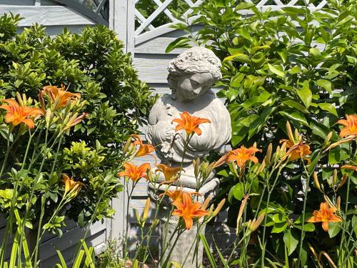 a statue in a garden with orange flowers at Ferienwohnung Preziosa in Idar-Oberstein