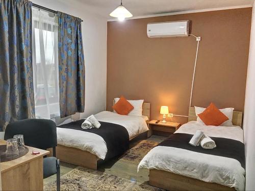 um quarto de hotel com duas camas e uma janela em Casa Bozi em Utvin