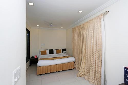 a bedroom with a bed and a window with curtains at OYO Flagship Hotel Golden Wings in Udaipur
