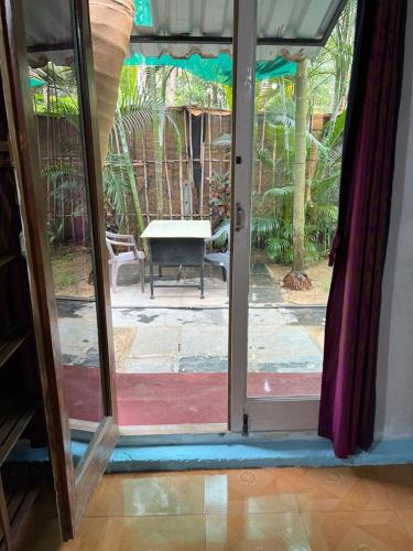 otwarte drzwi na patio ze stołem na zewnątrz w obiekcie Oceanic guest house w mieście Canacona