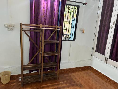 drewniana półka w pokoju z fioletowymi zasłonami w obiekcie Oceanic guest house w mieście Canacona