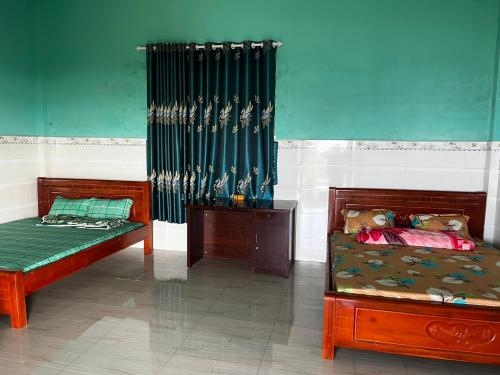 a bedroom with two beds and a green curtain at Phú Cường Tà Đùng Farmstay in Biđong