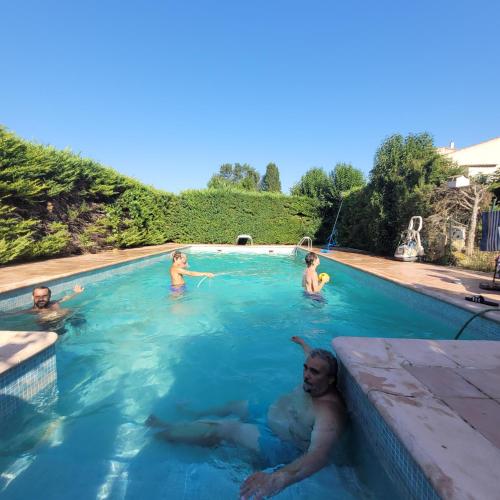 un groupe de personnes nageant dans une piscine dans l'établissement Mitten im Dorf und doch im Grünen, à Montblanc