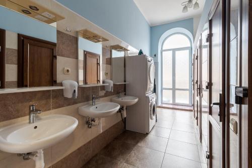 uma casa de banho com 2 lavatórios e uma janela em Soborniy Hostel em Lviv