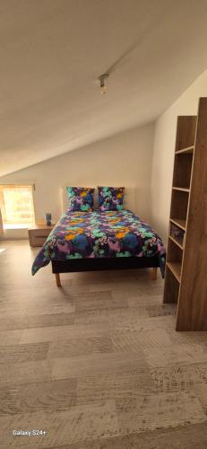 um quarto com uma cama com um edredão colorido em l alsace em Chantonnay