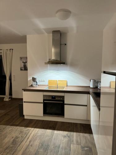 a kitchen with white cabinets and a stove top oven at Ferienhaus Wintermoor Ganzer Bungalow in Schneverdingen