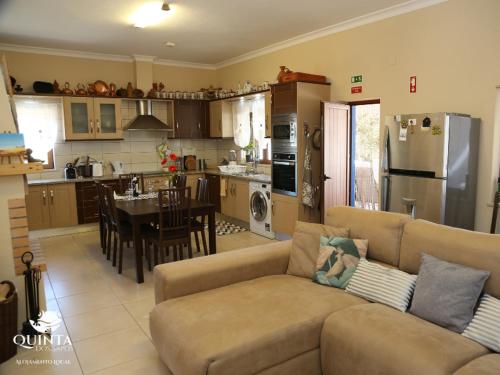 Una sala de estar y una cocina con un sofá y una mesa. en Quinta dos Sapos, en Silves