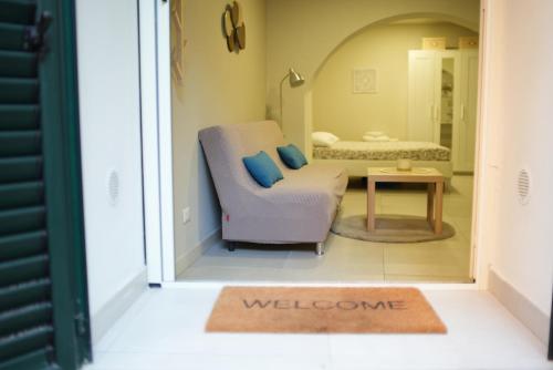 une porte menant à une chambre avec une chaise et un tapis de bienvenue. dans l'établissement Li Cuti Home, à Catane