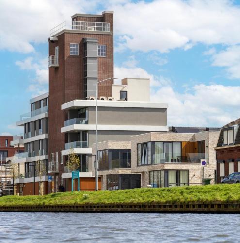 a building next to a body of water at B&B Mouttoren Weert in Weert