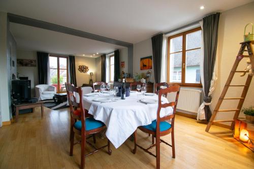 une salle à manger avec une table et des chaises blanches dans l'établissement Gîte de la tour des Fripons., à Kientzheim