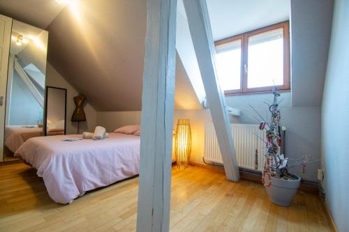 une chambre avec un lit dans un grenier dans l'établissement Gîte de la tour des Fripons., à Kientzheim