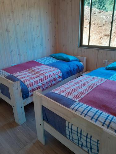 een kamer met 2 bedden in een hut bij Cabaña gam.nav in Vichuquén