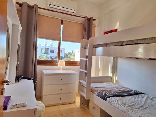 - une chambre avec des lits superposés, un bureau et une fenêtre dans l'établissement Kato Paphos Apt 400m To The Beach, à Paphos