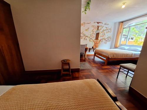 a bedroom with two beds and a window in a room at Hostal Chimenea in Baños