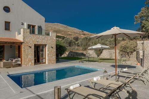 Villa con piscina con sillas y sombrilla en Villa Irini, en Koxaré