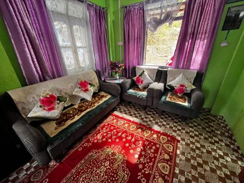 ein Wohnzimmer mit 2 Sofas und einem Fenster in der Unterkunft SILENT AM HOMESTAY in Darjeeling