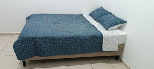 1 cama con edredón azul y 2 almohadas en ParadaHome en San Ramón