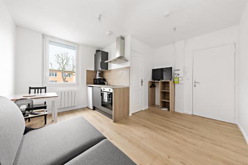 un salon avec un canapé et une table et une cuisine dans l'établissement Appart Coeur de Rouen - L'Avenue, à Rouen