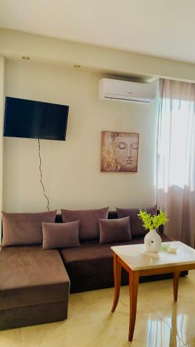 a living room with a brown couch and a table at Downtown Studio 41 in Serres