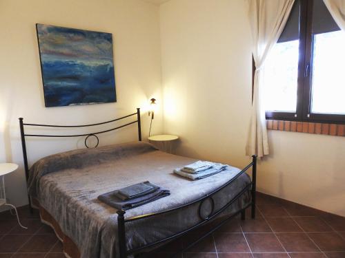 1 dormitorio con 1 cama con 2 toallas en Poggio la Luna la casa nel vigneto en Montemerano
