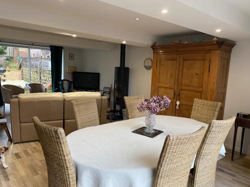 une table avec des chaises et un vase de fleurs dessus dans l'établissement ALAMER, à Lion-sur-Mer