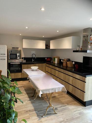 une cuisine avec une table au milieu dans l'établissement ALAMER, à Lion-sur-Mer