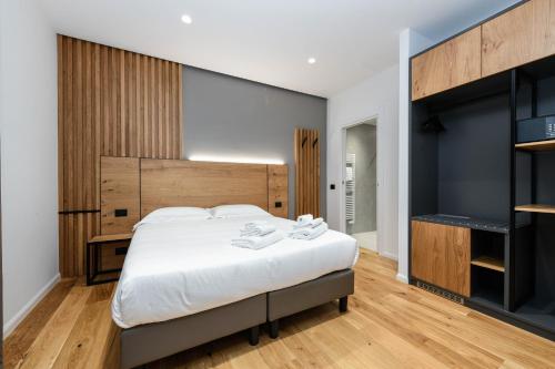 Schlafzimmer mit einem großen Bett mit einem Kopfteil aus Holz in der Unterkunft Hotel Mauro in Sirmione