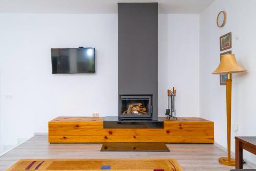 a living room with a wooden coffee table with a fireplace at Къщата на Mечтите / House of the Dreams in Apriltsi