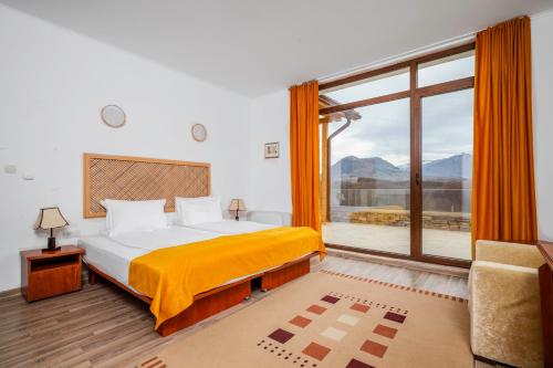um quarto com uma cama e uma grande janela em Къщата на Mечтите / House of the Dreams em Apriltsi