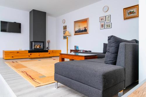a living room with a couch and a fireplace at Къщата на Mечтите / House of the Dreams in Apriltsi