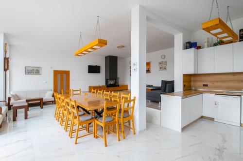 a kitchen and dining room with a table and chairs at Къщата на Mечтите / House of the Dreams in Apriltsi