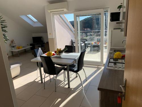 cocina y sala de estar con mesa y sillas en Apartments Orchidea, en Dubrovnik