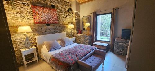Porri的住宿－Domaine COLONNA SANTINI ,Chambre d hôtes Piscine, sauna, spa，一间卧室设有一张床和石墙